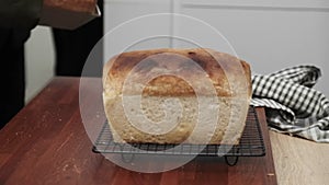 Close-up of a chef\'s hands taking baked bread out of a pan. the cook takes the bread out of the oven