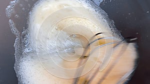 Close up chef whisks fresh raw natural egg in the  bowl