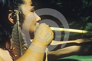 Close-up of Cherokee using a blow gun, Tsalagi Village, Cherokee Nation, OK