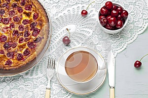 Close up of cherry pie on a plate with a bowl of cherries