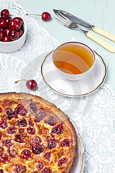 Close up of cherry pie on a plate with a bowl of cherries