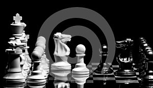 Close up of Chess pieces on a reflective mirror board surface wi