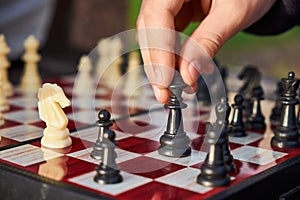 A close-up of a chess player's hand holding a king piece