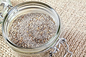 Close up of Chia seeds in a jar on linen background.