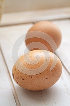 Close up of chicken eggs, fresh farm brown eggs over a rustic wooden table. Vertical image