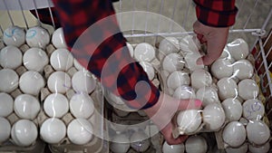 Close-up of chicken eggs on a shop window. A woman's hand takes a tray of eggs. Food shopping concept.