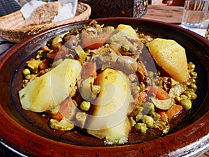 Close up of Chicken Tajine, Moroccan slow-cooked stew served and cooked in earthenware pot.