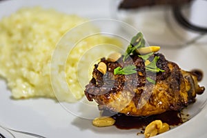 Close up of chicken in thai sauce decorated with fresh parsley and peanuts on the white plate