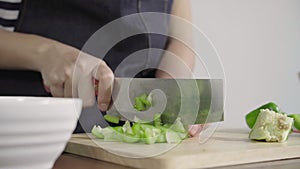 Close up of chief woman making salad healthy food and chopping bell pepper on cutting board