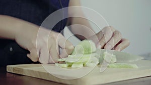 Close up of chief woman making salad healthy food and chopping cucumber on cutting board