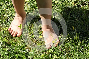 Close-up of a child barefoot on the lawn - a symbol of ecology