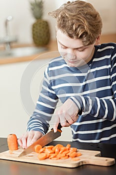 Close up on child carefully cutting carrots