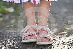 Close up of child girl feet wearing summer sandals shoes