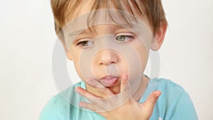 A close-up of a child with an insult, puffed up lips. The child is thoughtful, does not want to hear anybody, keeps