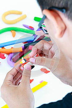 Close up. Child molding model clay, on white background. Strengthen the imagination.