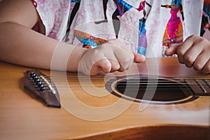 Close-up child playing guitar. Concept of liftstyle, learning, hobby, musician, dream and imagination.