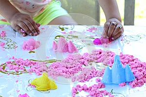 Close-up of a child playing with molds in the sand - a symbol of ecology