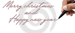 Close-up of a child hand with a pen writing  merry christmas and Happy new yea by hand on white paper on a white background photo