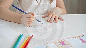 Close-up of a child's hands coloring a drawing with bright pencils. Young girl engaging in colorful artistic drawing