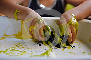 CLOSE UP OF CHILD`S HANDS PLAYING WITH HANDMADE GALACTIC SLIME