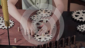 Close-up of a child who collects wooden gears.