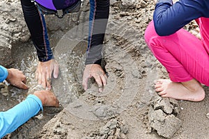 Close up of children hands playing in sand on the beach-dig a hole