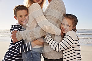 Close Up Of Children Hugging Parents On Winter Beach