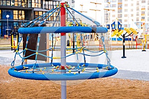 Close-up of a children's blue carousel on a playground in a big city