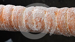 Close up chimney cake baking and rolling