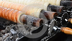 Close up chimney cake baking and rolling