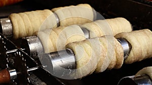 Close up chimney cake baking and rolling