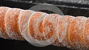 Close up chimney cake baking and rolling