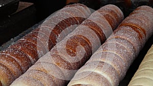 Close up chimney cake baking and rolling