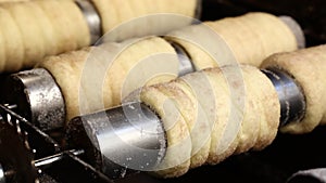 Close up chimney cake baking and rolling