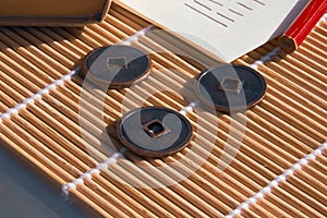 Close-up of Chinese coins, together with a pencil and paper and