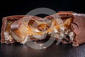 Close up of chocolate candy bar with caramel filling, snapped in half