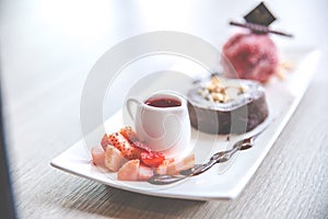 Close up the chocolate lava dessert with strawberry ice cream on white plate