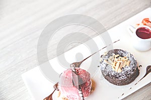 Close up the chocolate lava dessert with strawberry ice cream on white plate