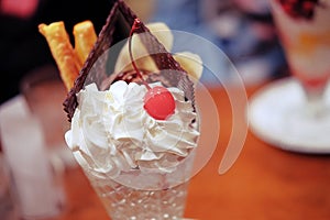 close up, a chocolate parfait served with chocolate wafer, cherry, bread stick and banana