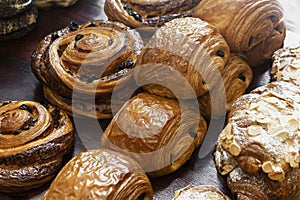 Close-Up of Chocolate Pastries, Almond Croissants, and Spiral Raisin Danish