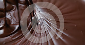Close-up chocolatier mixing melted liquid chocolate with steel whisk. Hot chocolate mix and swirl in bowl. Cooking