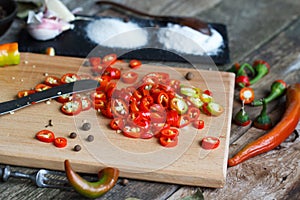 Close-up of chopped hot chili peppers, bay leaf and pepper chopped on a vintage fork on an old wooden surface, selective focus