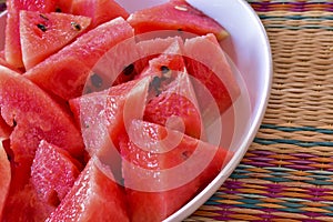 Close up of chopped red watermelon in white plate put on local m