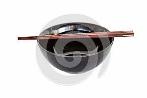 Close up chopsticks and black bowl isolated .