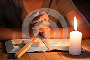 Close up of Christian boys  are reading and study bible In the room and lit candles to light, Religious concepts