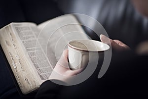 Eine Frau lesen die Bibel a trinken Tee oder kaffee 