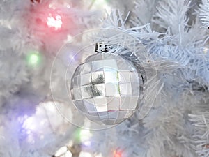 Close up christmas accessories hanging on decorated with lights Christmas tree. Christmas decorations on a spruce branch, copy