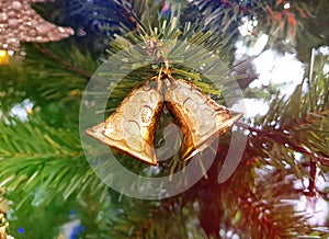 Close up christmas accessories hanging on decorated with lights Christmas tree. Christmas decorations on a spruce branch, copy