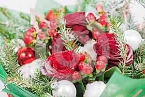 Close-up of Christmas bouquet with flowers and spruce with snow.