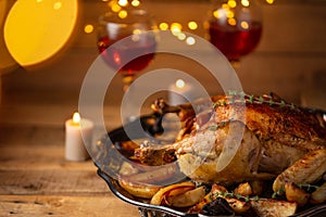 Close-up of Christmas dinner with baked turkey, glasses of red wine and candles. Christmas traditions. Holiday concept. Wooden